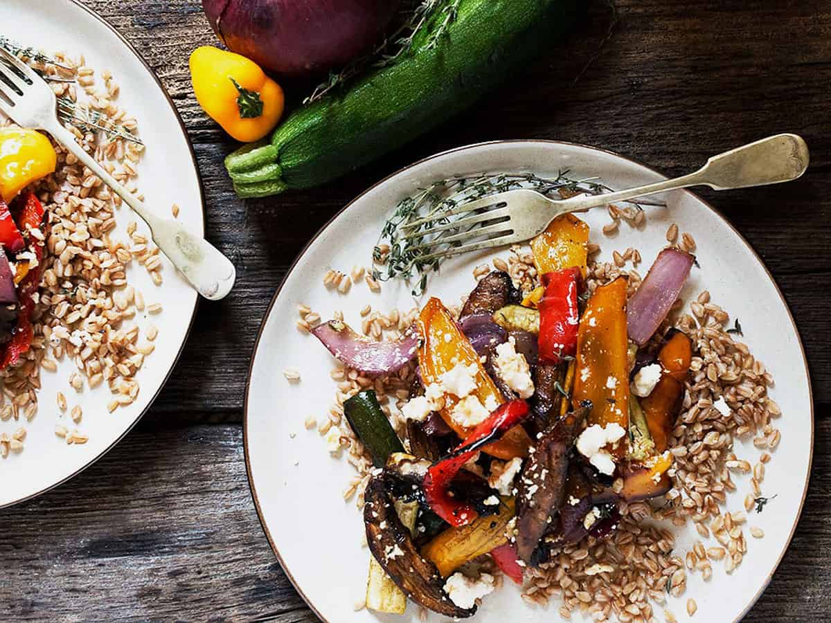 farro and roasted vegetable salad on white plate with fork