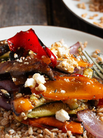 Roasted vegetable farro salad on a plate with a fork.