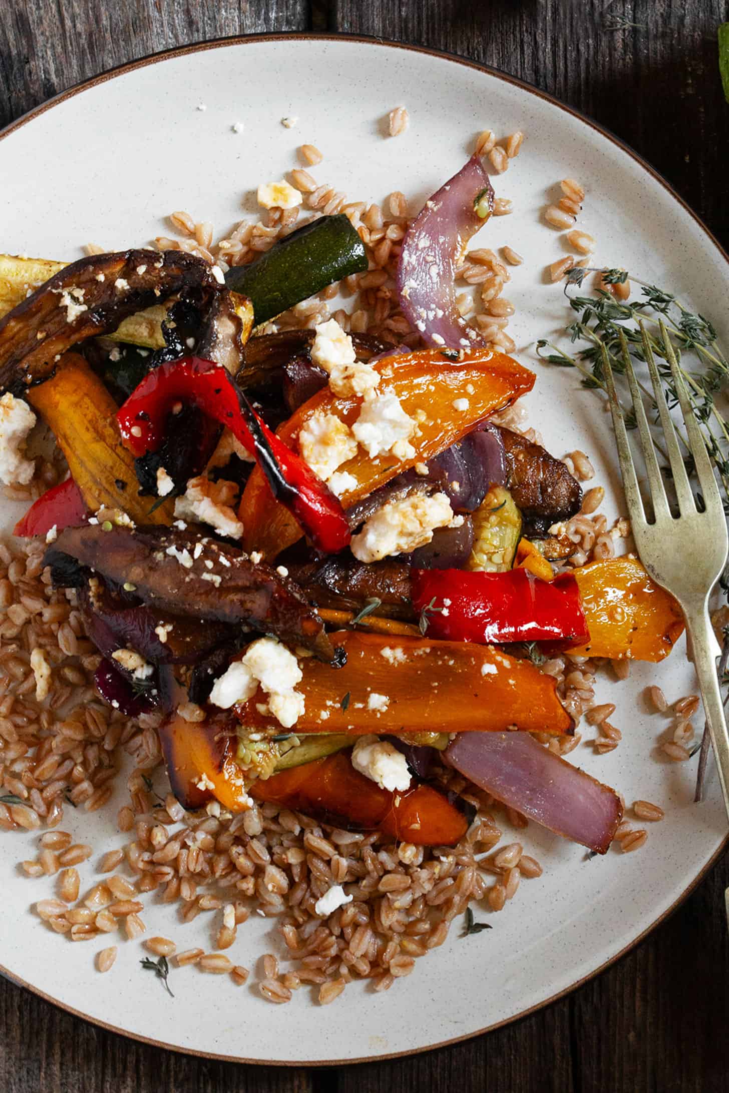 Roasted vegetable farro salad on a plate with a fork.