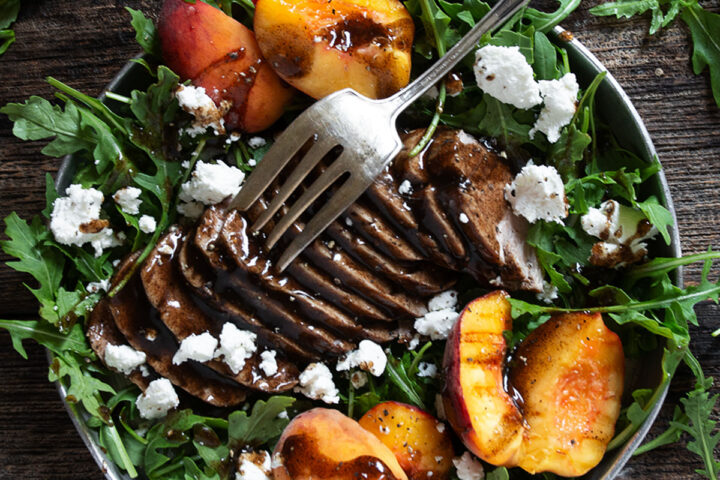 balsamic pork and peach salad with arugula and goat cheese