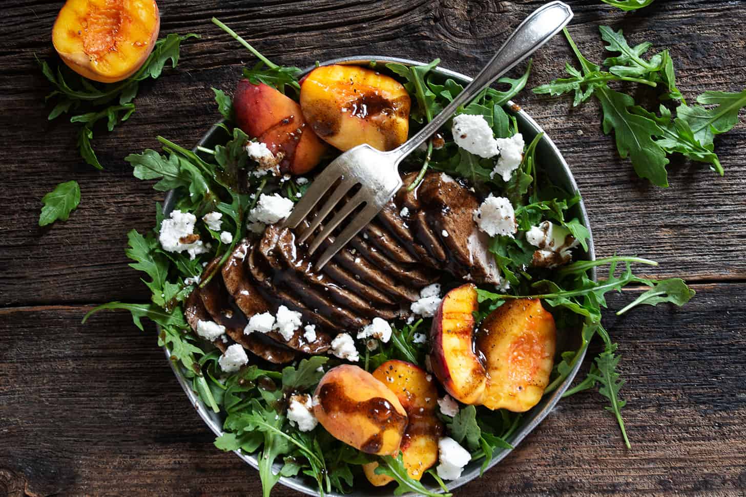 balsamic pork and peach salad with arugula and goat cheese