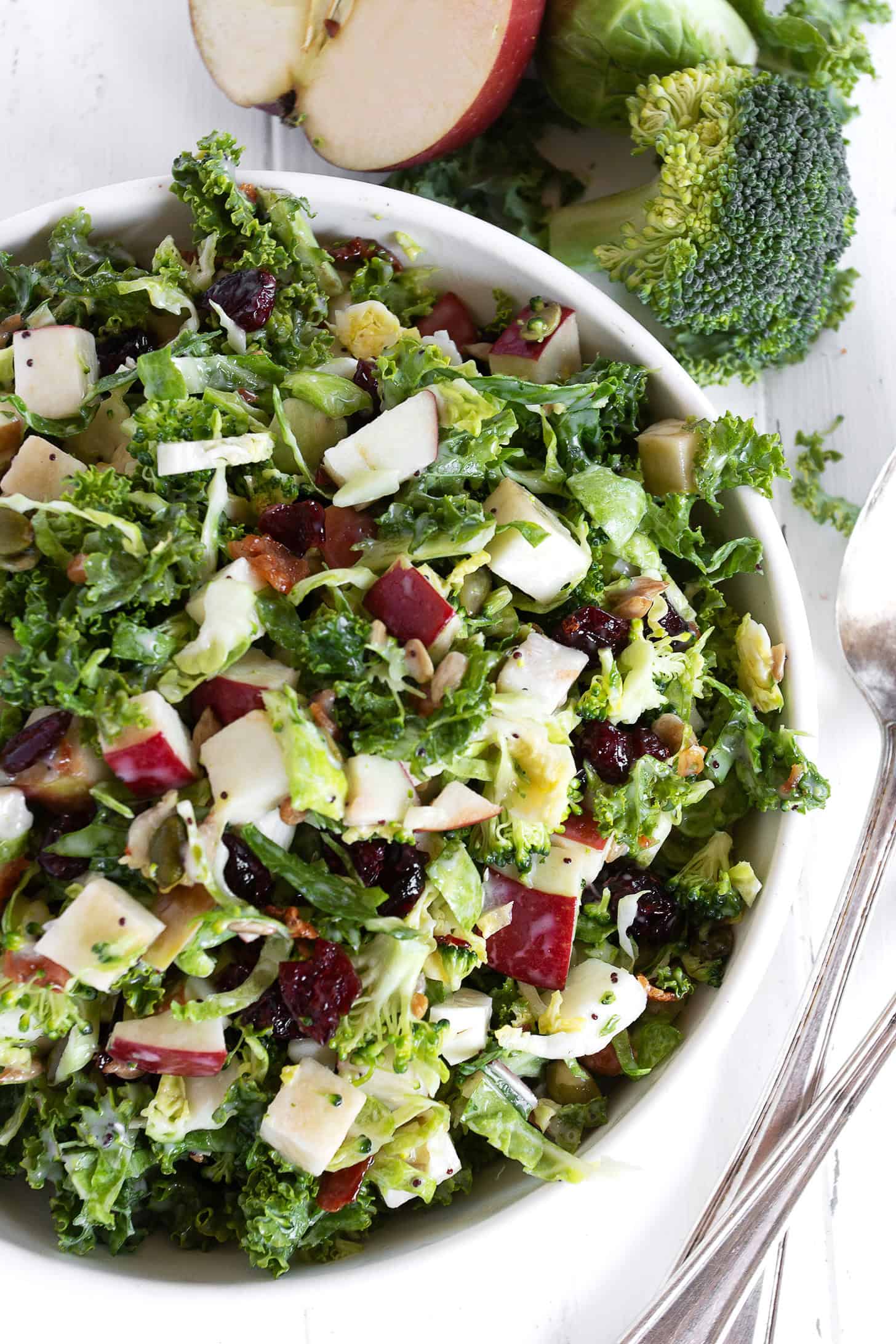 Fall kale and apple salad with Brussels sprouts and broccoli in a serving bowl.