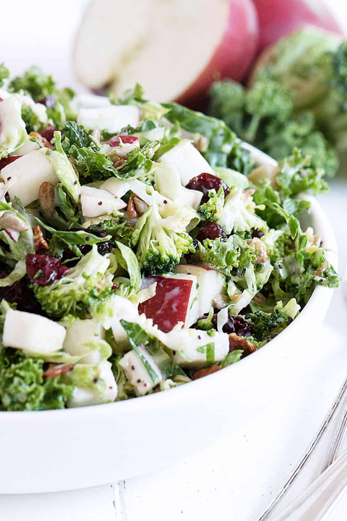 Fall kale salad with apple in white bowl