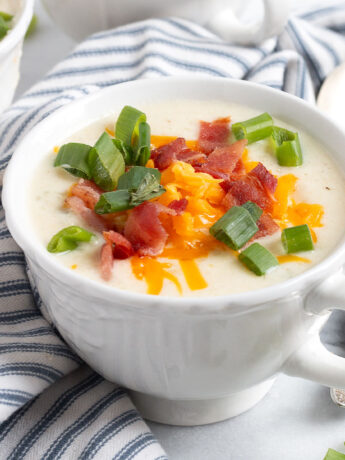 Loaded cauliflower soup in soup cup.
