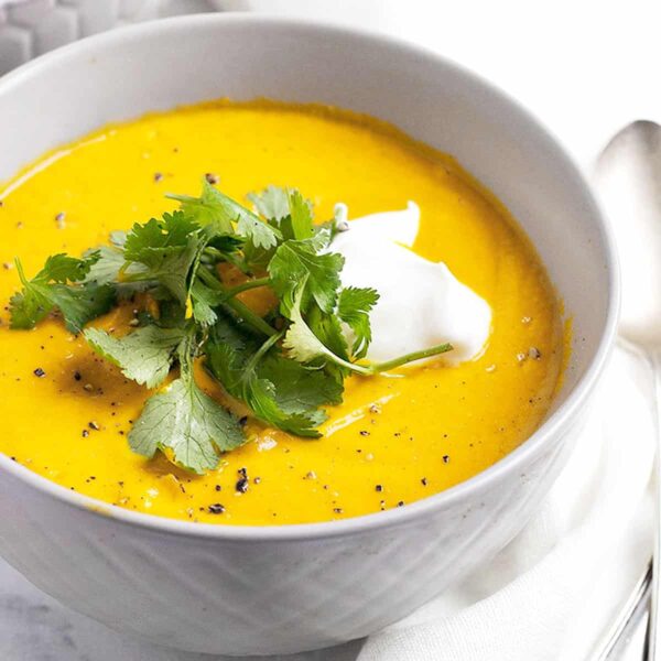 Thai carrot soup in bowls with cilantro and sour cream
