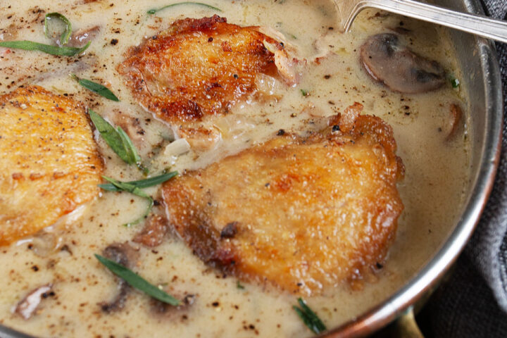 saucy French chicken in serving dish with spoon