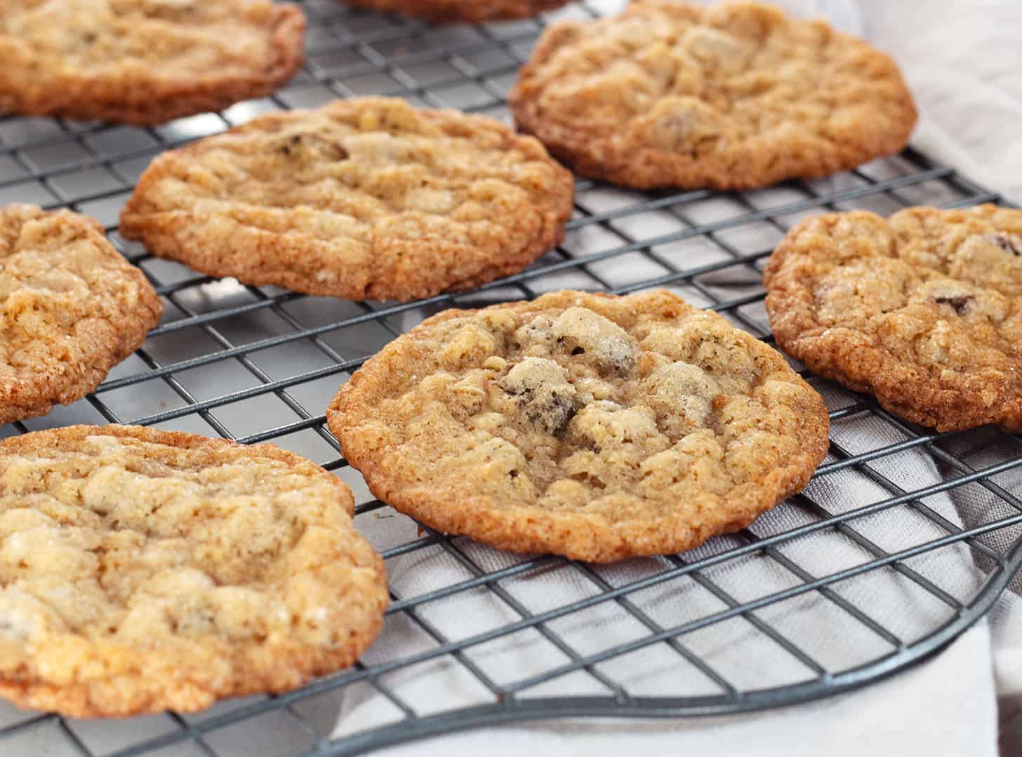 crispy oatmeal chocolate chip cookies on cooling rack