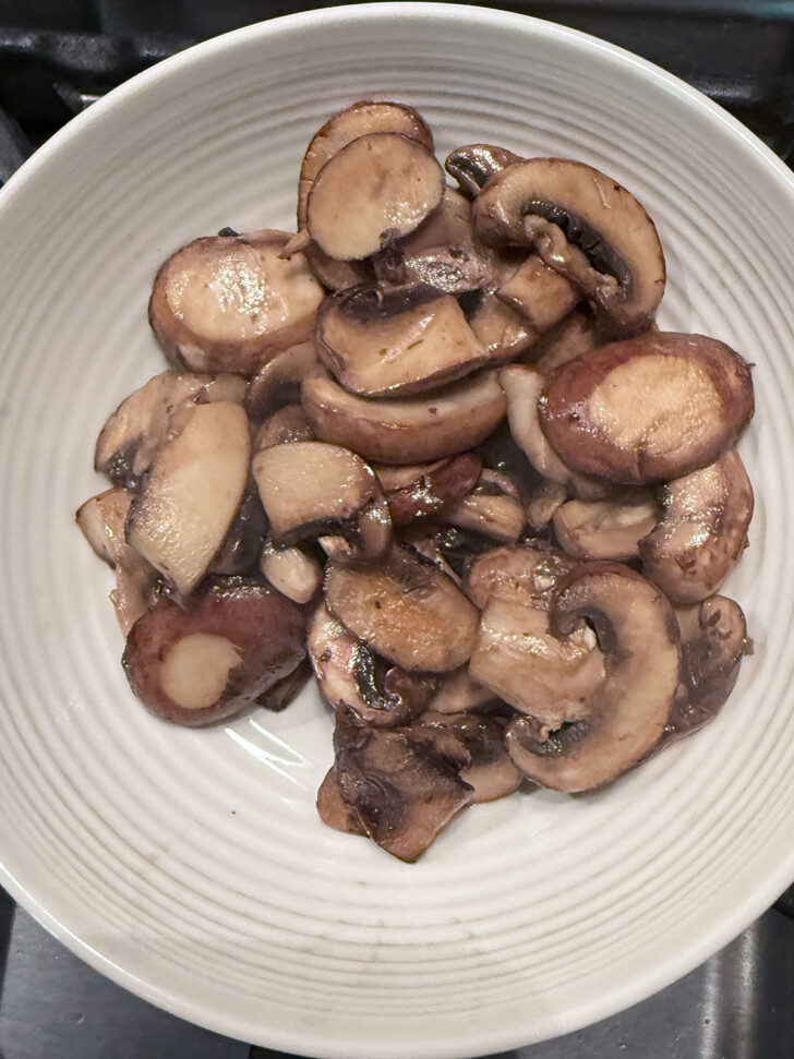 Cooked mushrooms removed to a bowl.