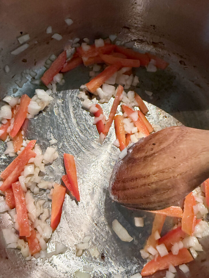 Cooking the peppers and onion in the soup pot.