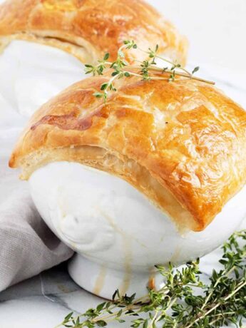 chicken pot pie in white bowls with puff pastry topping