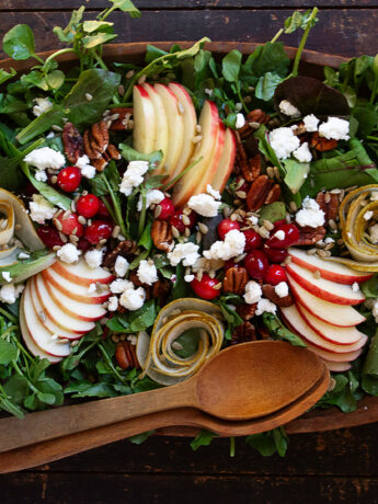 Fall harvest salad in wooden bowl with wooden spoons