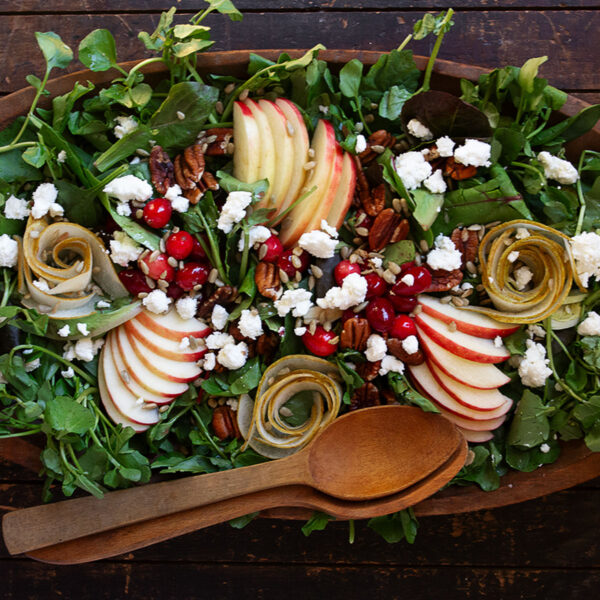 Fall harvest salad in wooden bowl with wooden spoons