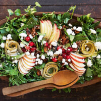 Fall harvest salad in wooden salad bowl with wooden spoons