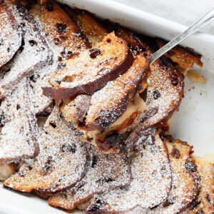 Gruyere pear bread pudding in baking dish with spoon