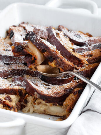 Gruyere and pear bread pudding in baking dish with spoon.