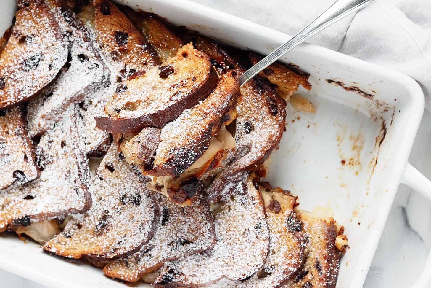 Gruyere pear bread pudding in baking dish with spoon