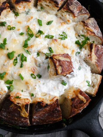 crab dip in a bread bowl all in a cast iron skillet