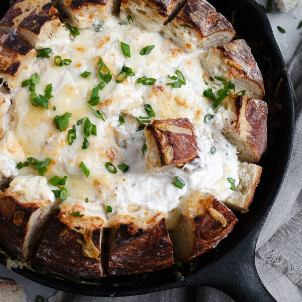crab dip in a bread bowl all in a cast iron skillet