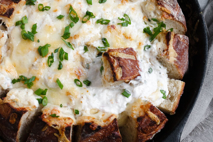 crab dip in a bread bowl all in a cast iron skillet