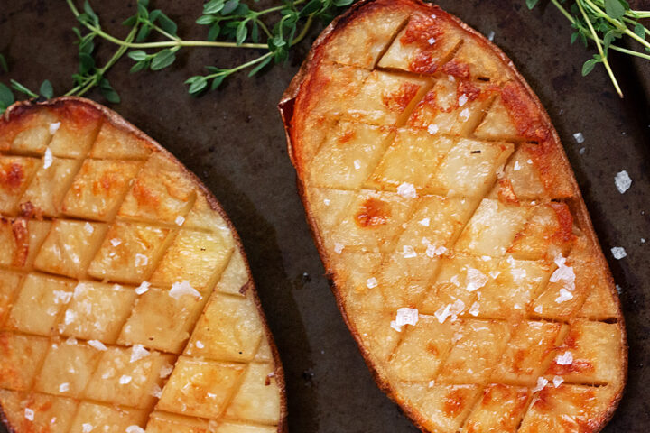 Salt and malt vinegar roasted potatoes on a baking sheet.
