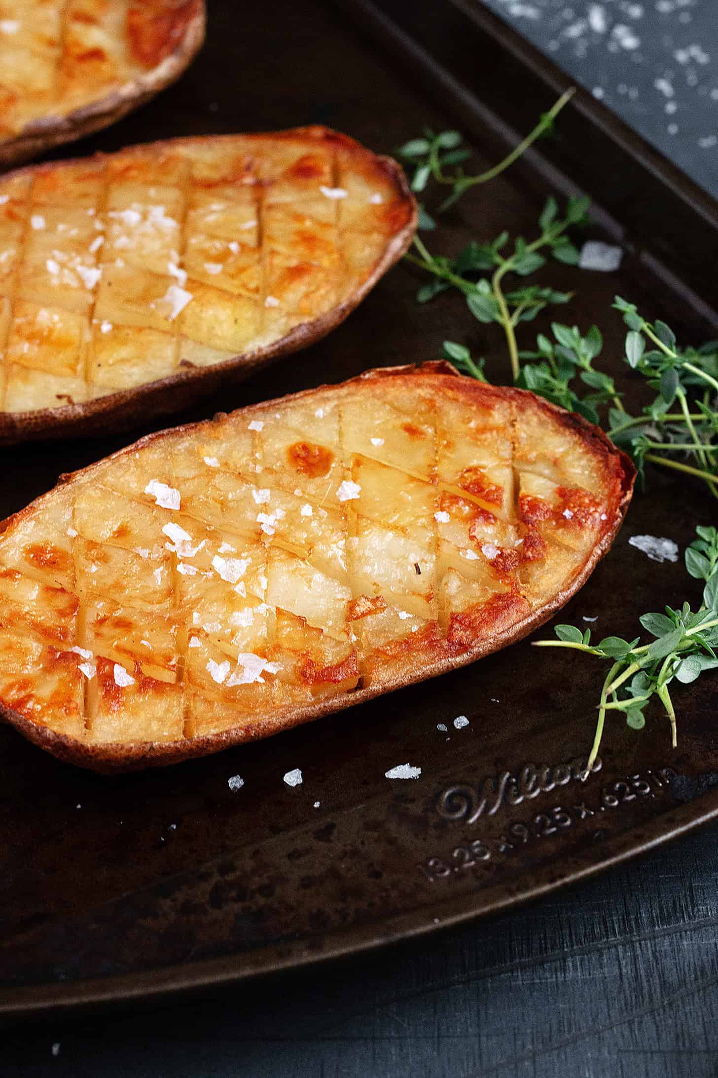 Salt and malt vinegar roasted potatoes on a baking sheet.