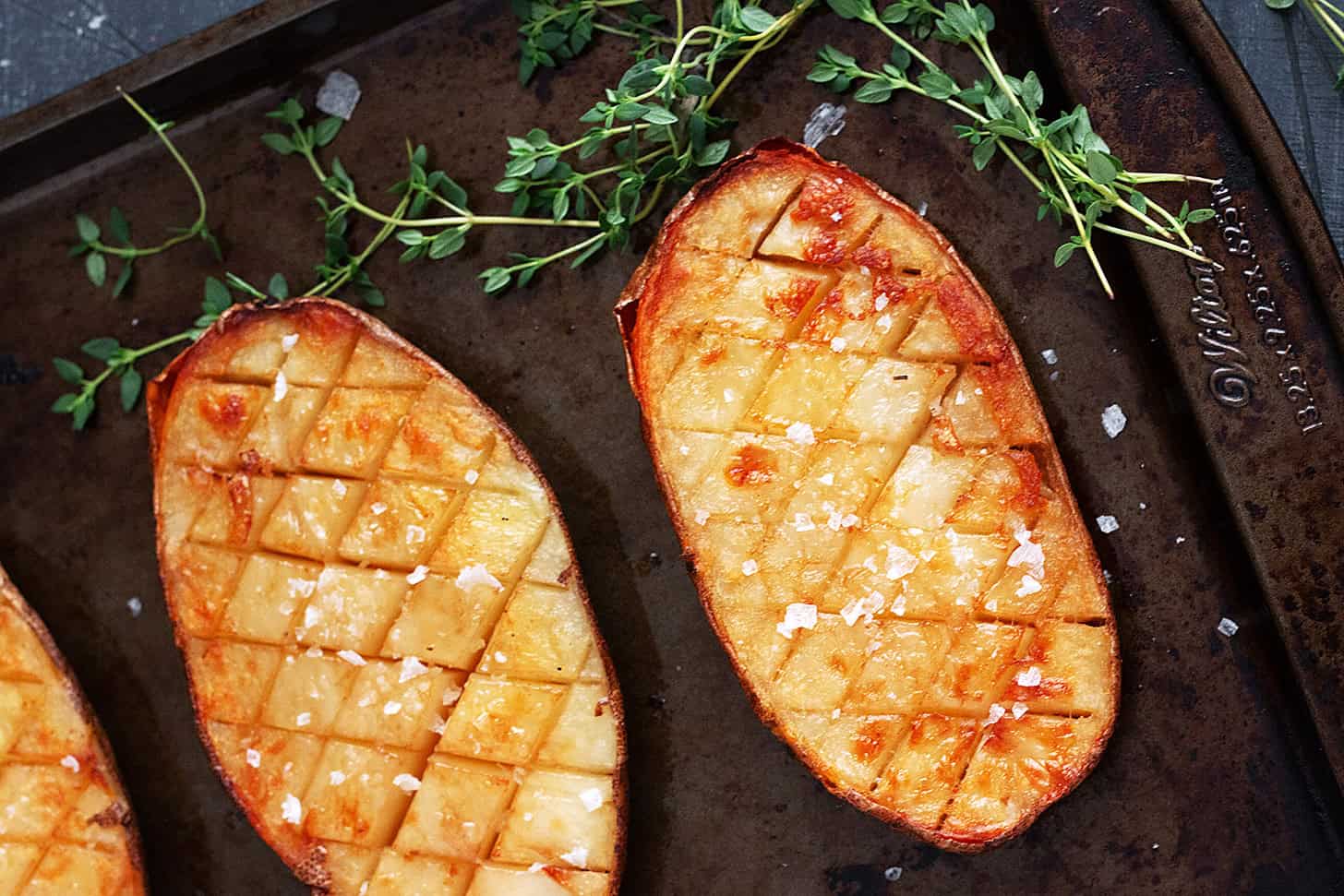 Salt and malt vinegar roasted potatoes on a baking sheet.