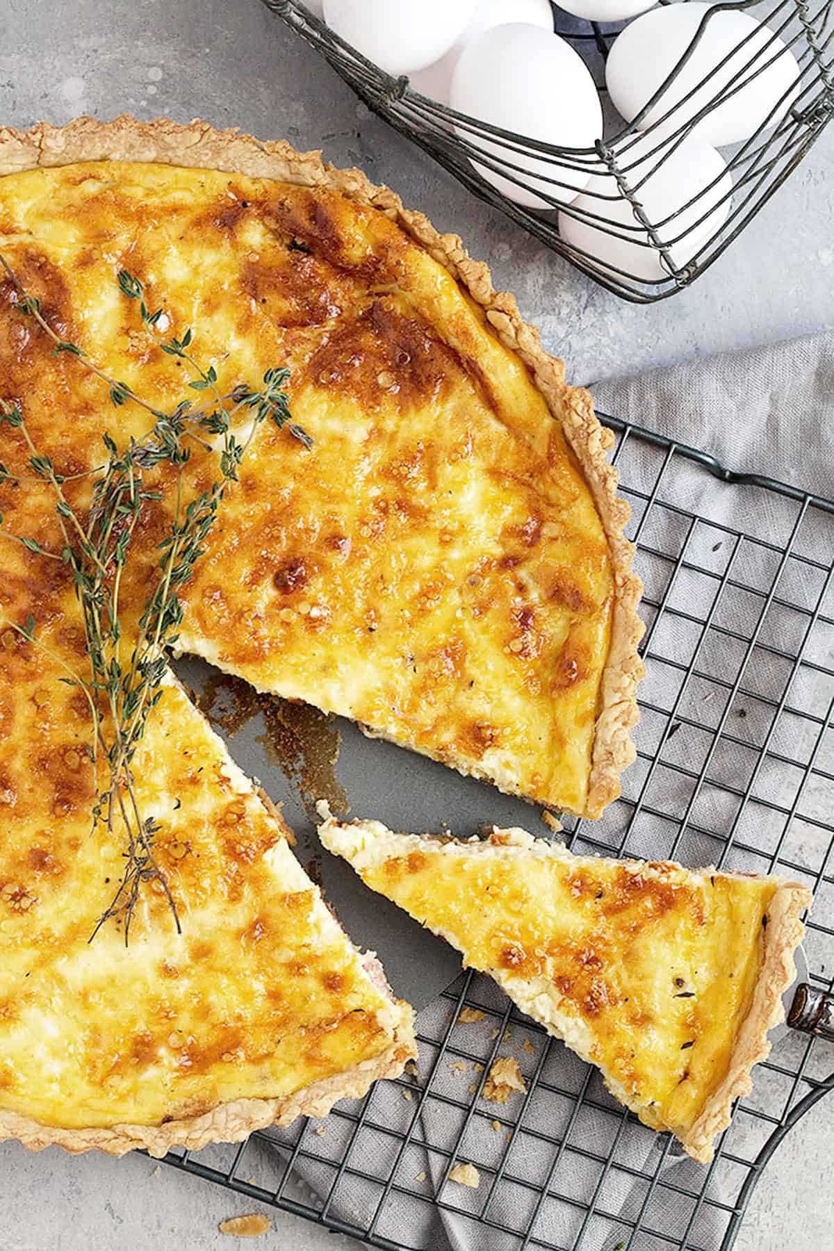 classic quiche lorraine on cooling rack sliced