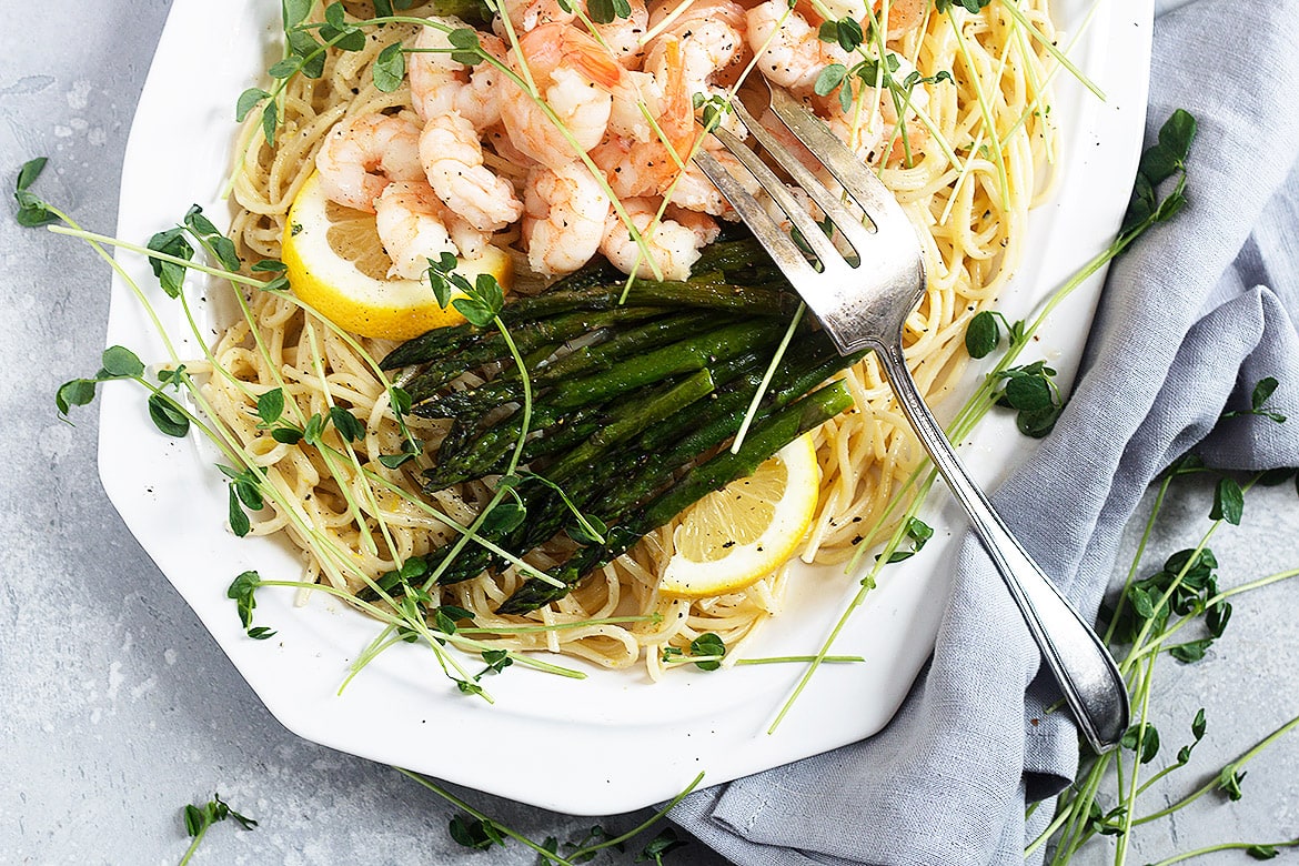 Creamy shrimp asparagus pasta on plate with fork.