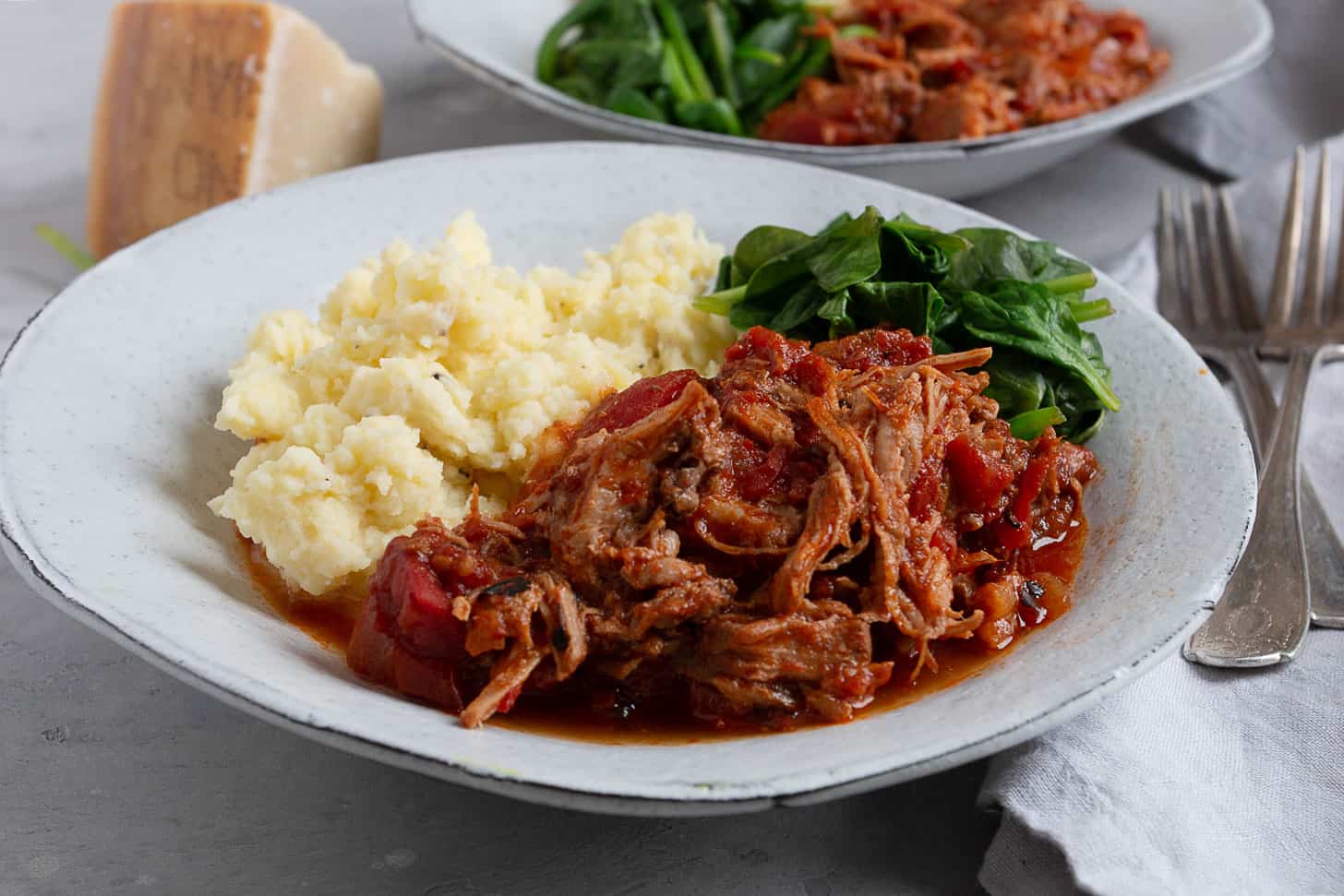 pork arrabbiata on plate with mashed potatoes and spinach