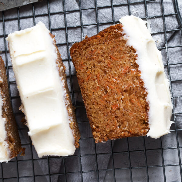 Carrot cake loaf with cream cheese frosting sliced.