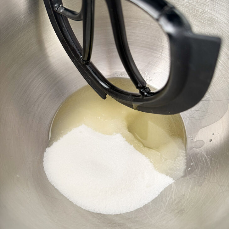 Oil and sugar in the bowl of a stand mixer.