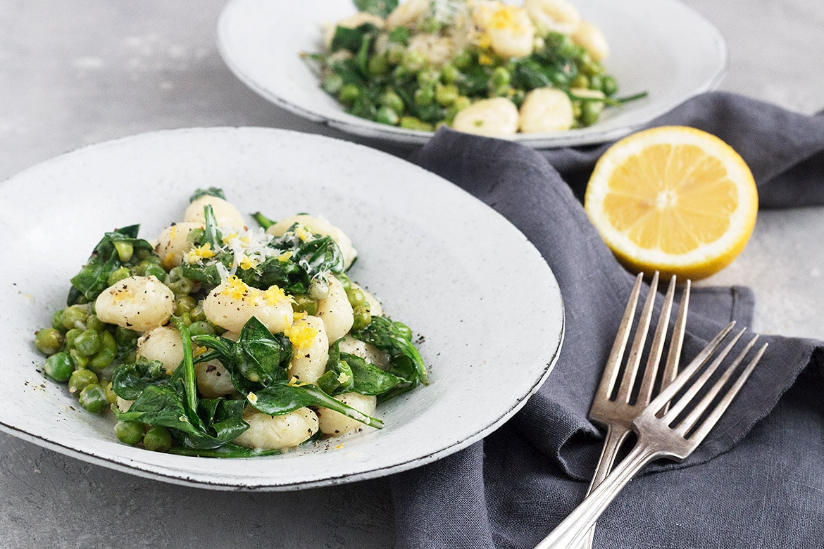 gnocchi with peas, spinach and lemon in a bowl