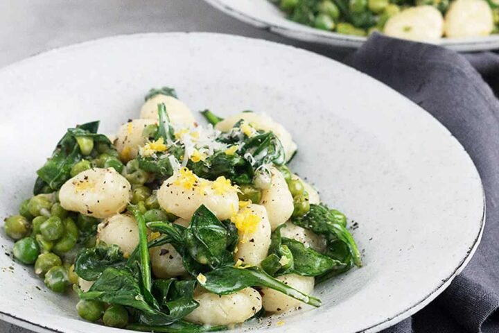 gnocchi with lemon peas and spinach in bowl