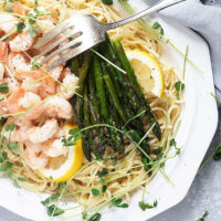 lemon pasta with shrimp and asparagus on white platter