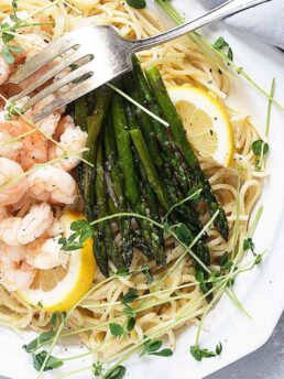 lemon pasta with shrimp and asparagus on white platter