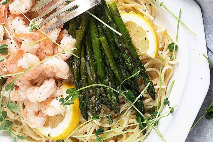 lemon pasta with shrimp and asparagus on white platter