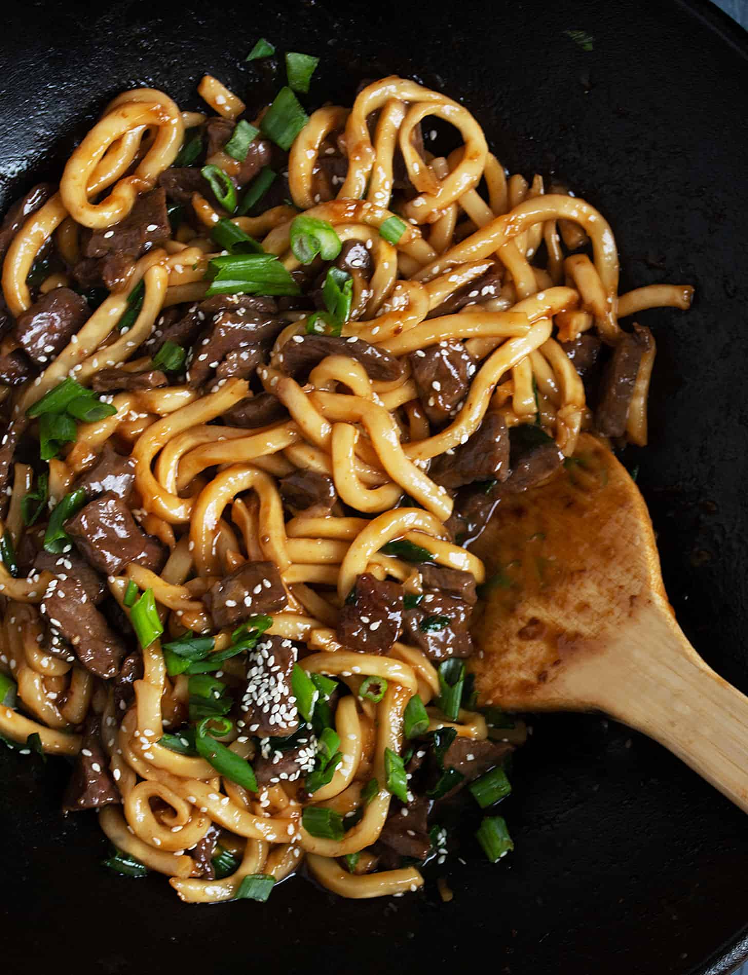 Mongolian beef udon in wok with wooden spoon