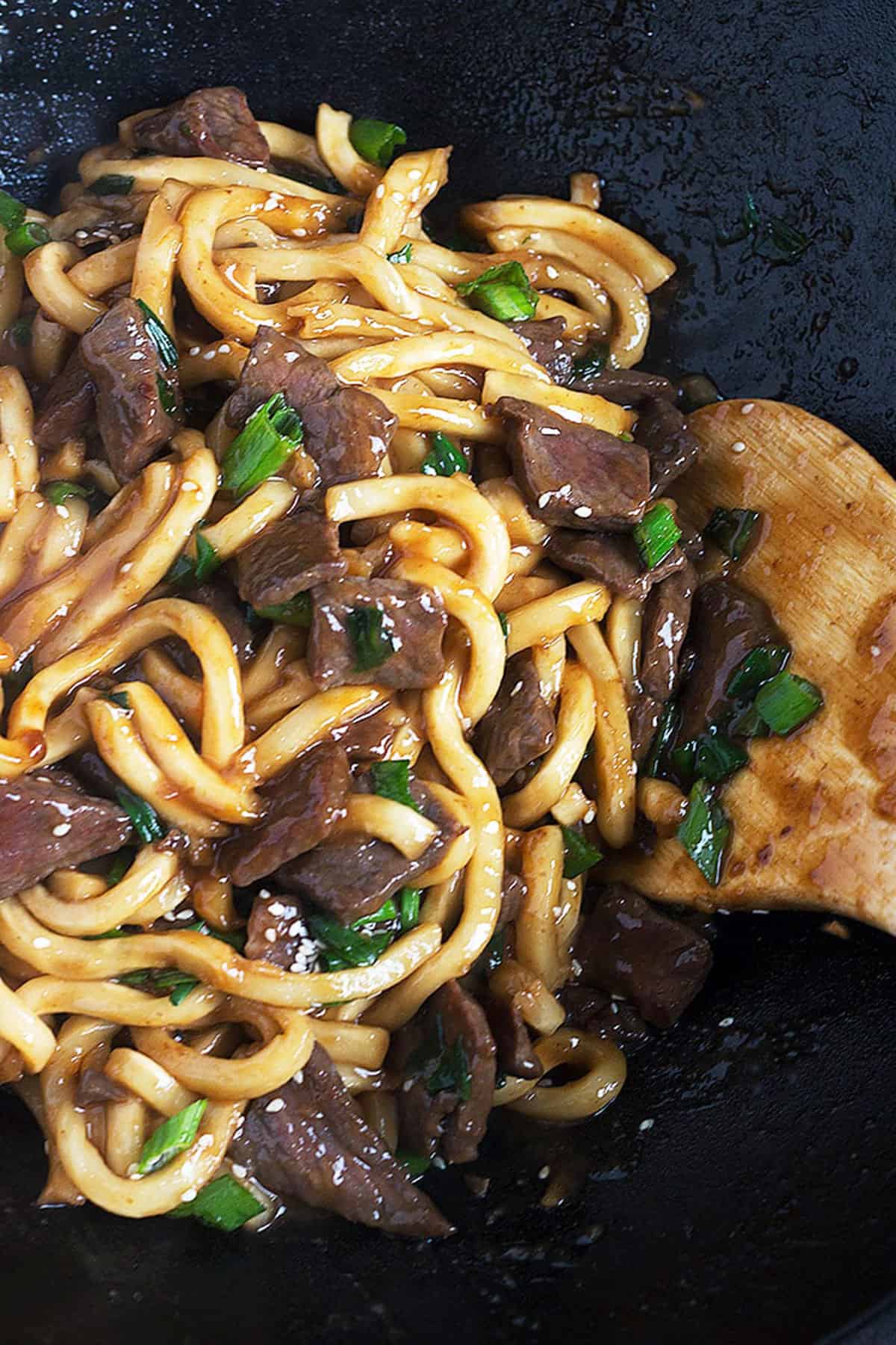 mongolian beef and udon noodles in cast iron wok