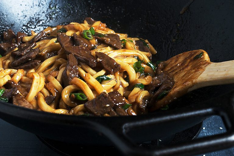 mongolian beef udon stir fry in a cast iron wok