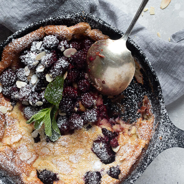 blackberry Dutch baby in cast iron skillet with spoon