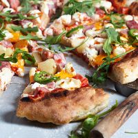 hawaiian pizza sliced with pizza cutter
