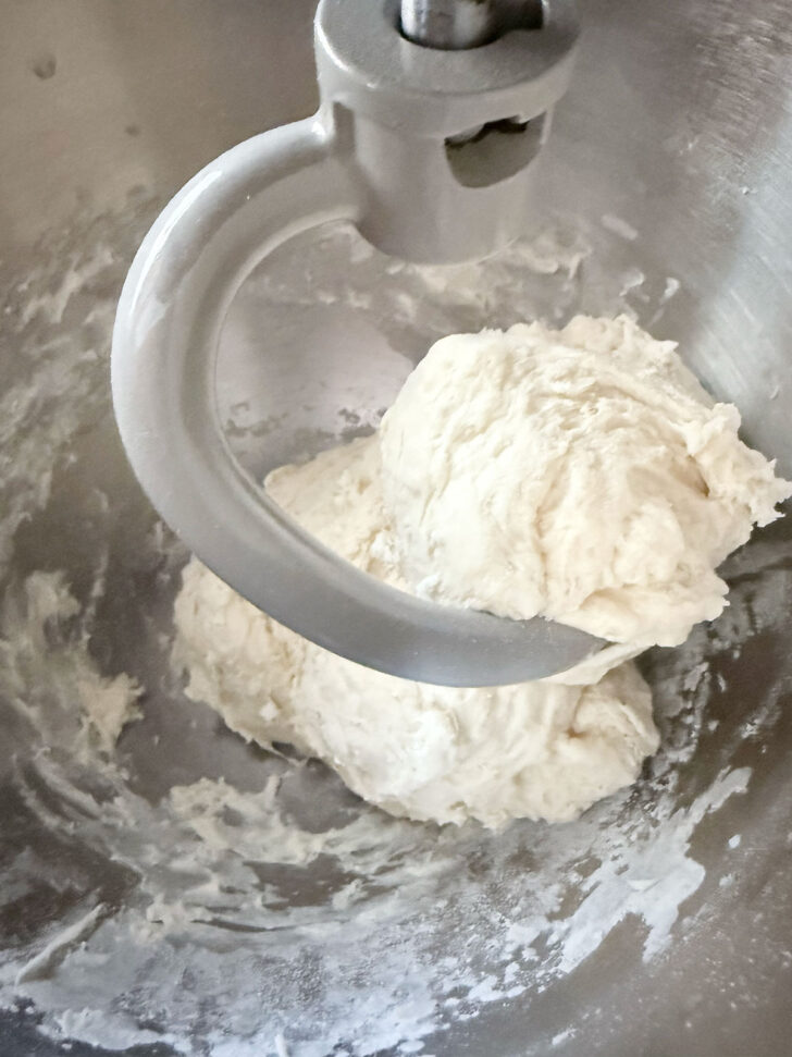 Pretzel dough in mixer after mixing in some of the flour.