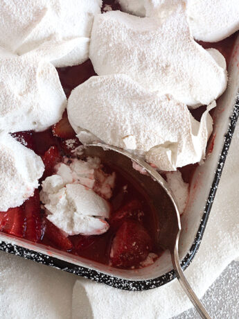 strawberry meringue dessert in baking dish with spoon