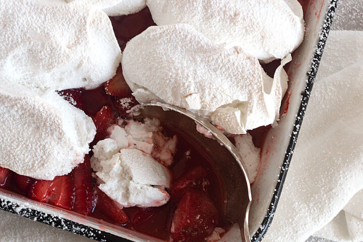 strawberry meringue dessert in baking dish with spoon