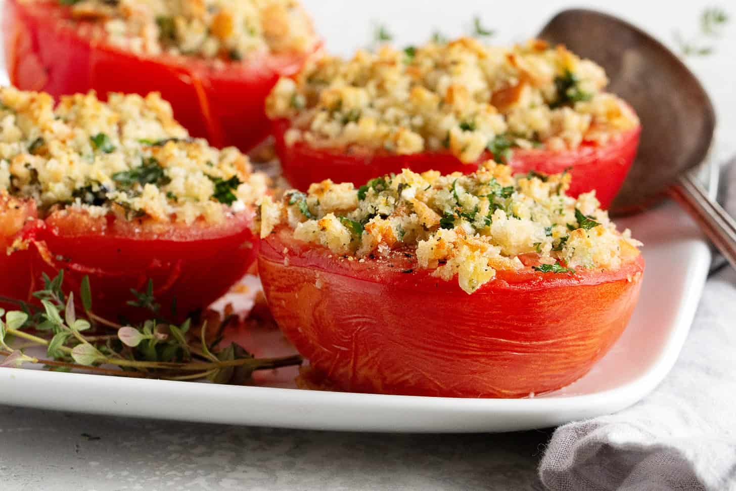 Goat cheese stuffed baked tomatoes topped with bread crumbs.