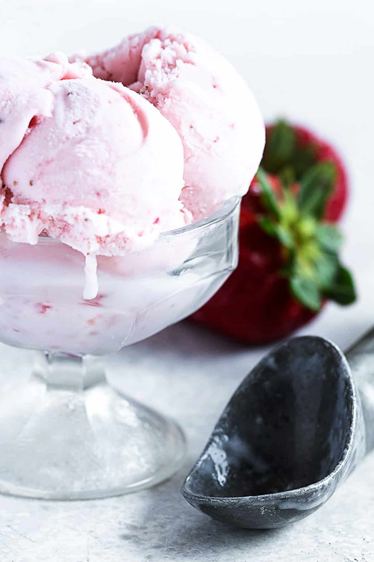 strawberry ice cream in cup with scoop
