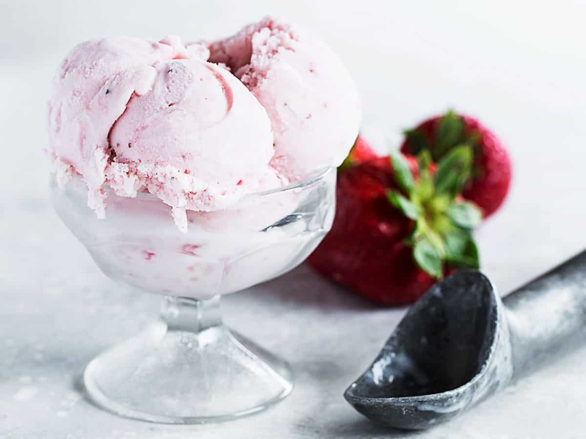 strawberry ice cream in cup with scoop