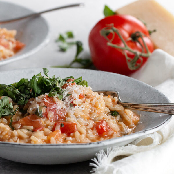 tomato basil risotto in bowl with fork