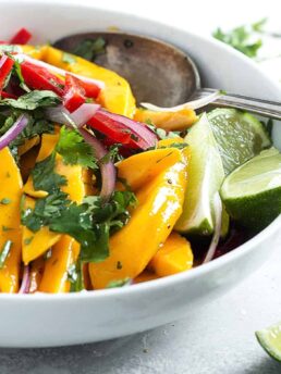 mango salad in white bowl with spoon