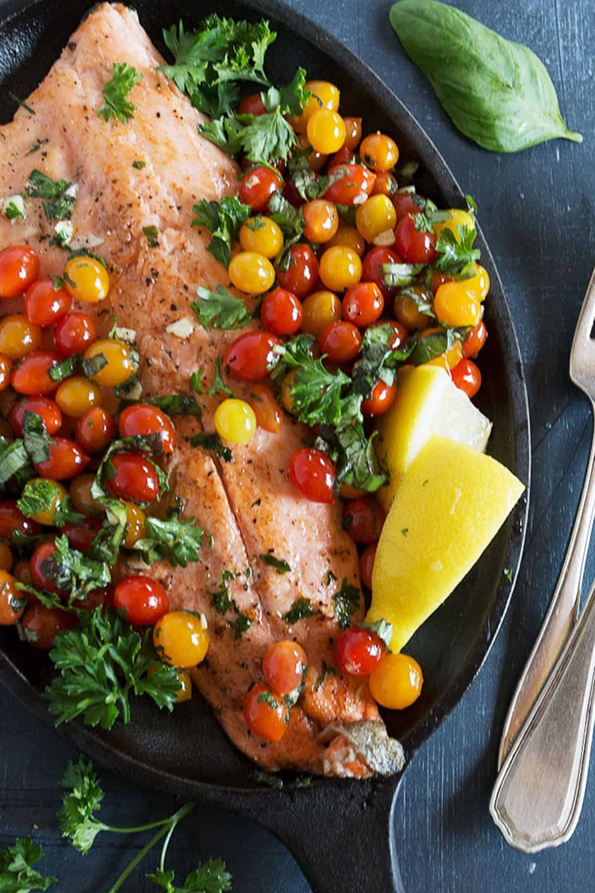 rainbow trout with mini cherry tomatoes in skillet